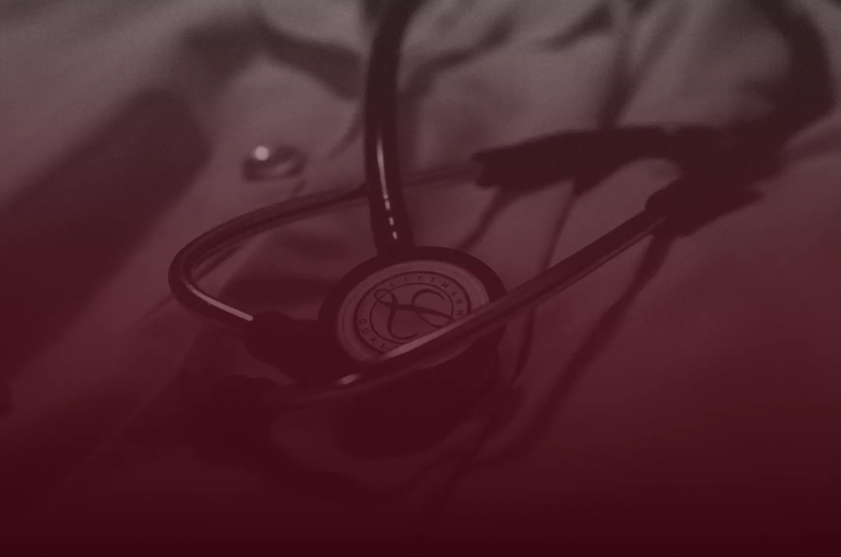 Photograph of a stethoscope resting on a clinician’s desk